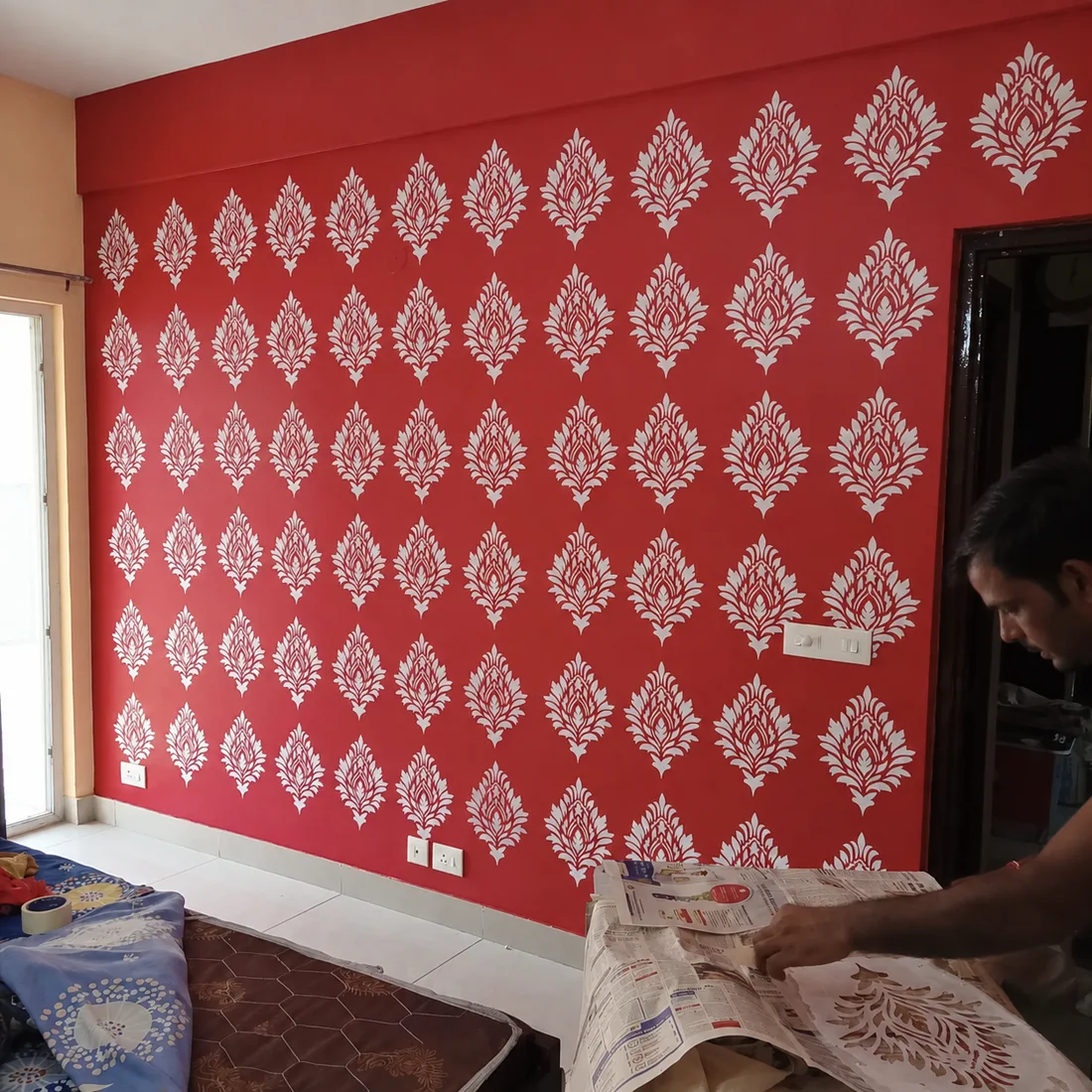 Red feature wall with hand-finished white stencil pattern